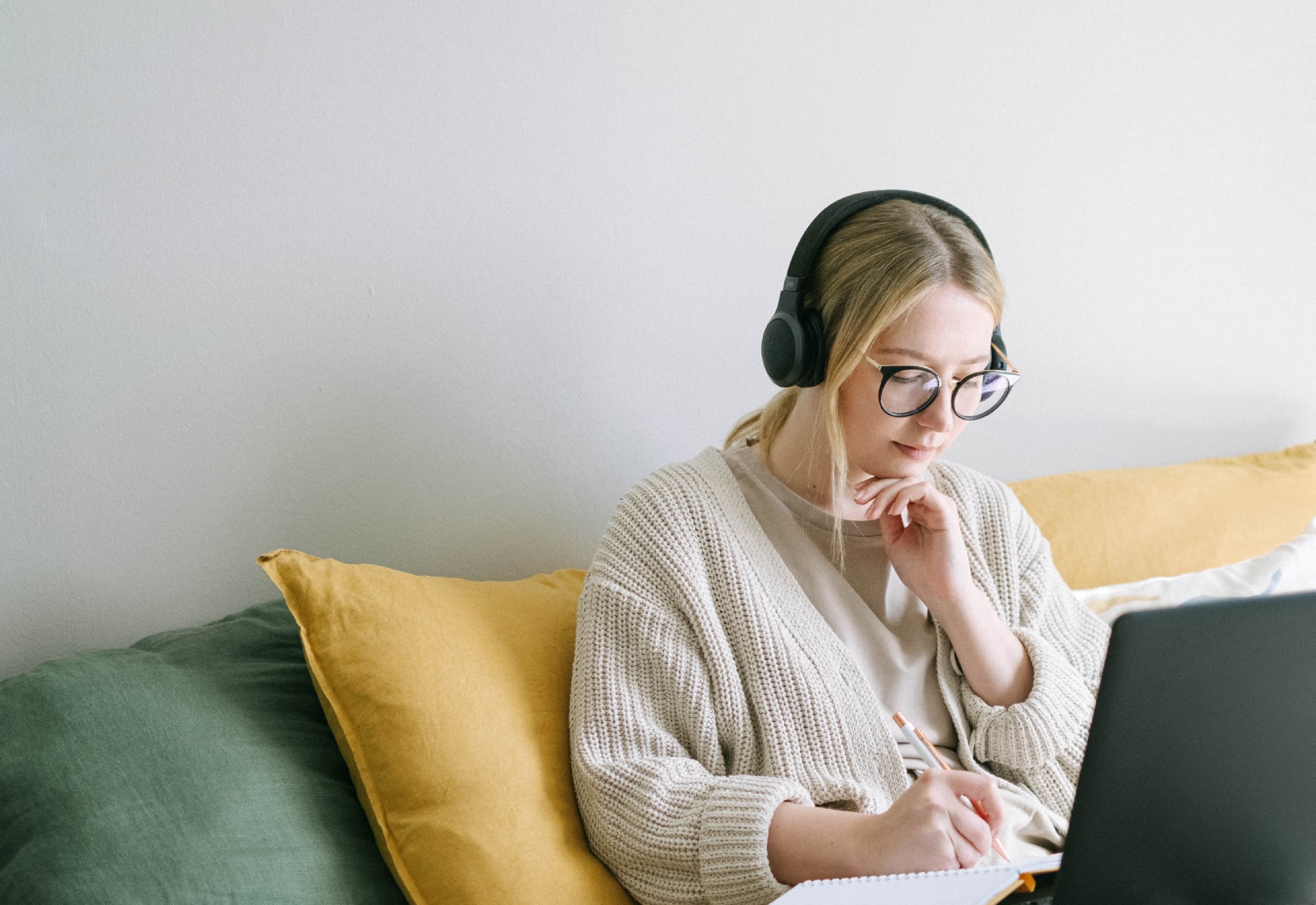 Girl at home on laptop, wearing headphones.